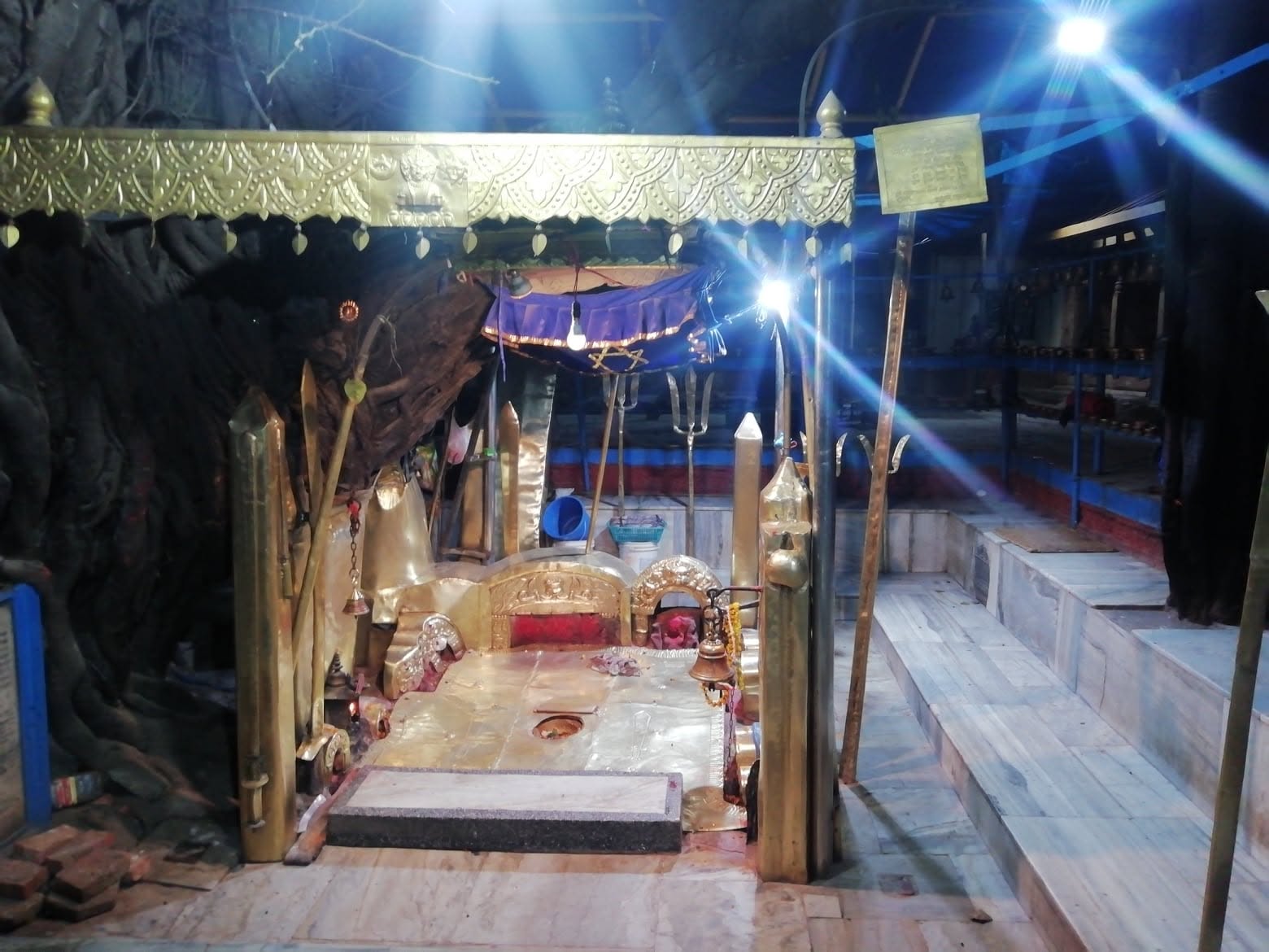 The shrine of Pachali Bhairava at Teku, Kathmandu, set among the roots of the old tree and worked in gilded metal