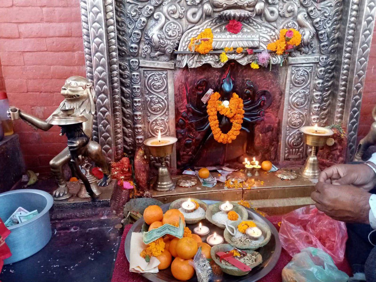 Offerings of lamps, marigold and rice set before the shrine of Sobha Bhagavati